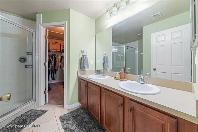 a spacious bathroom with a shower sink and mirror