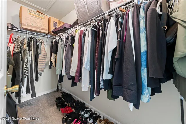 a view of walk in closet with clothes and shoes