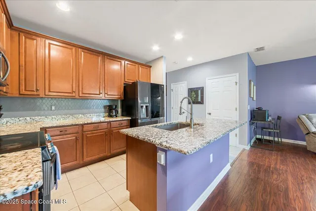 a kitchen with stainless steel appliances granite countertop refrigerator sink and cabinets