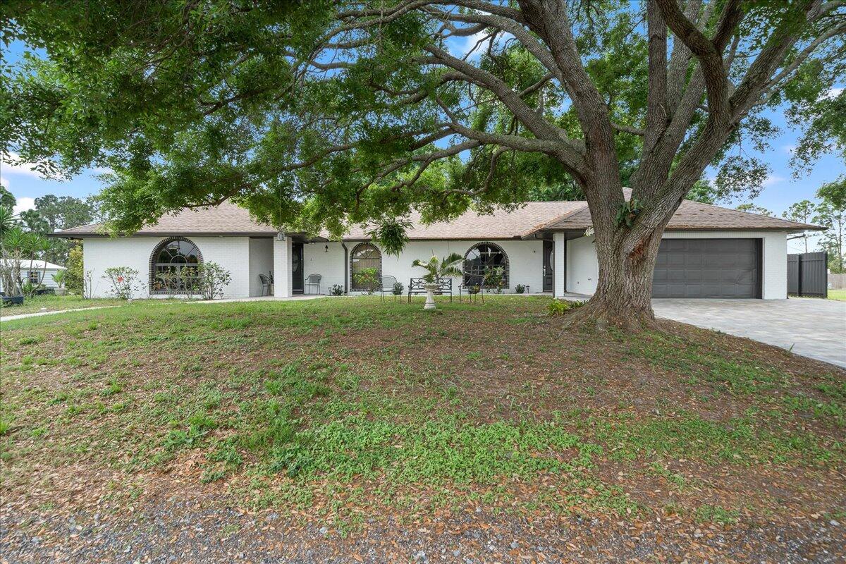 613 Grant Road Palm Bay, FL 32909 - Photo 1 of 40 a front view of a house with a garden
