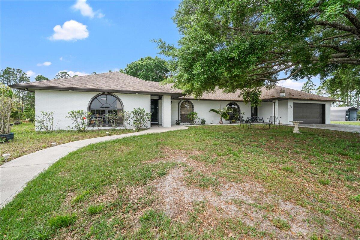 613 Grant Road Palm Bay, FL 32909 - Photo 2 of 40 a view of a house with a yard and sitting area