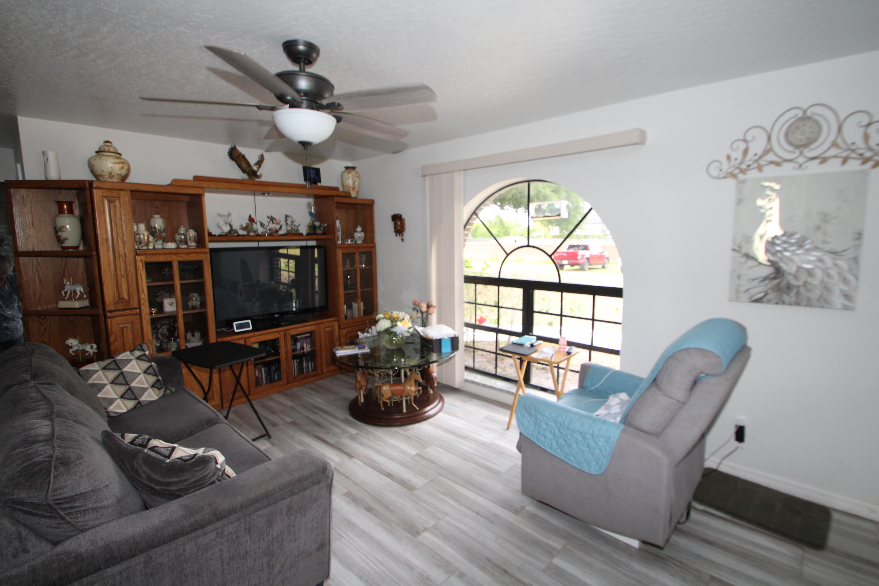 613 Grant Road Palm Bay, FL 32909 - Photo 23 of 40 a living room with furniture a flat screen tv and a large window