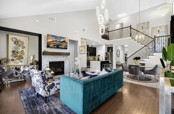 a living room with furniture a fireplace and a chandelier