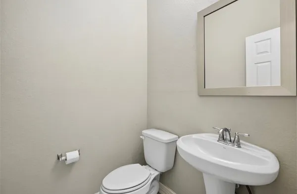 a white toilet sitting next to a bathroom sink