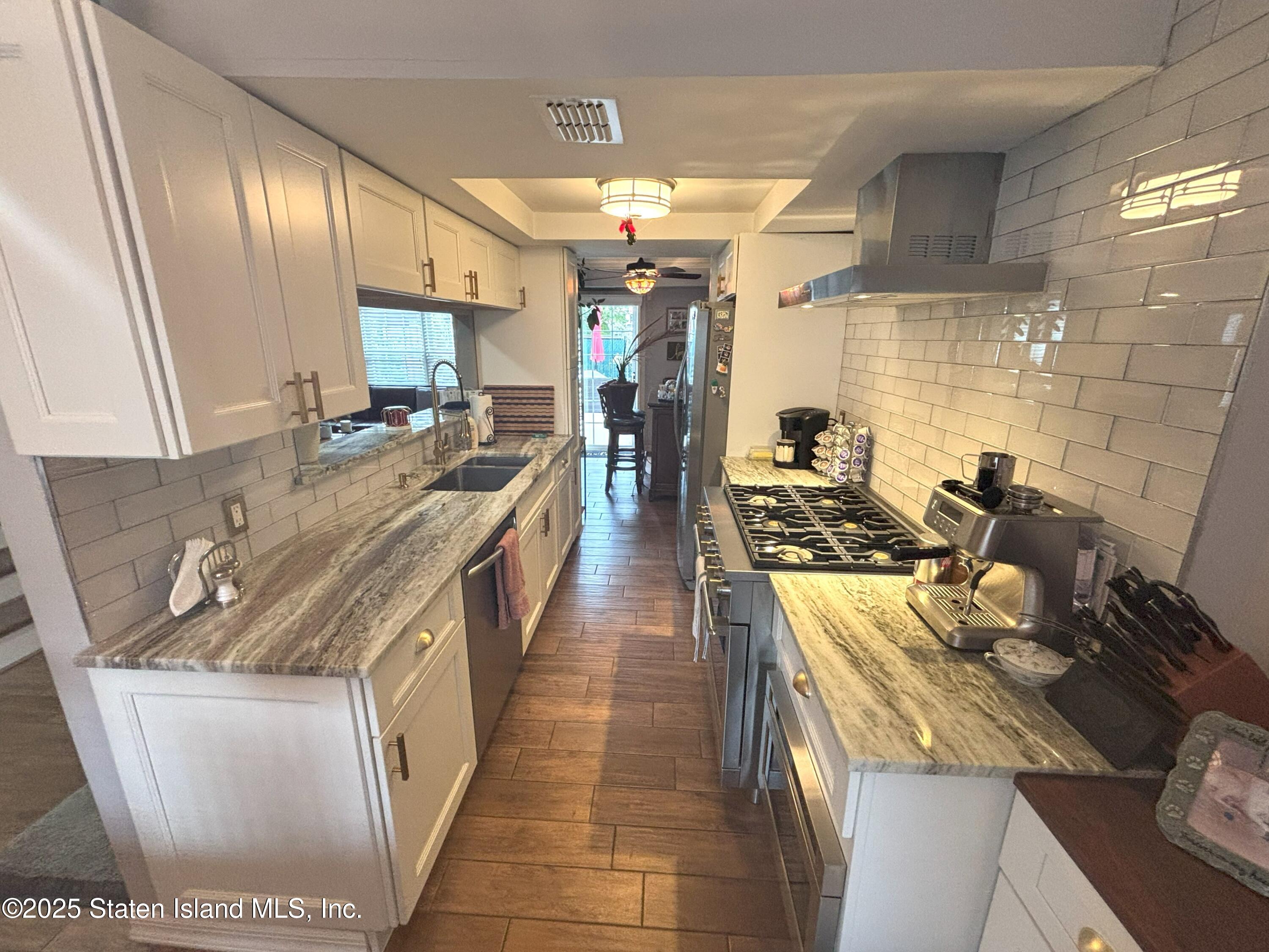 73 Hampton Green Staten Island, NY 10312 - Photo 5 of 28 a kitchen with stainless steel appliances granite countertop a sink stove and cabinets