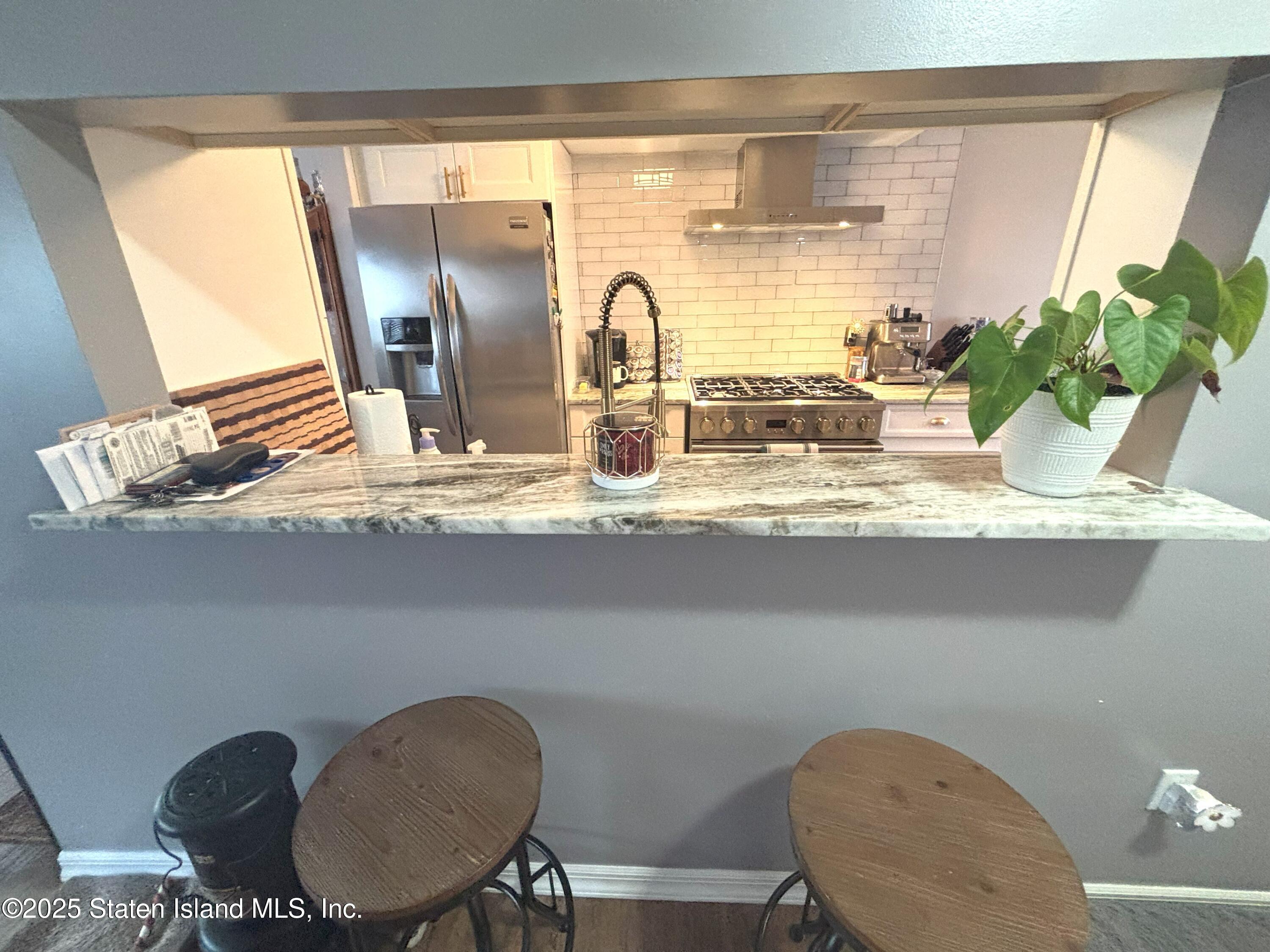 73 Hampton Green Staten Island, NY 10312 - Photo 8 of 28 a bathroom with a granite countertop sink a mirror and a toilet