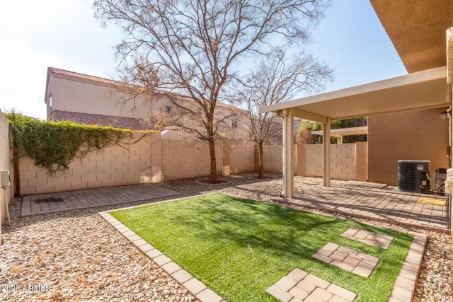 a backyard of a house with lots of green space and glass windows