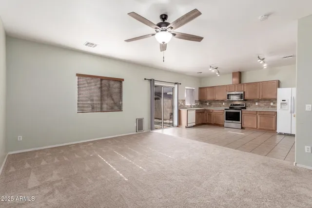 a view of a kitchen with a stove cabinets a ceiling fan and wooden floor