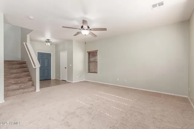 an empty room with a ceiling fan and window
