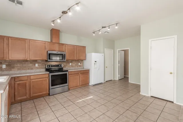 a kitchen with white cabinets and appliances