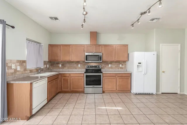a kitchen with a stove sink and cabinets