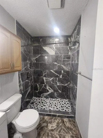 a bathroom with a toilet and a shower