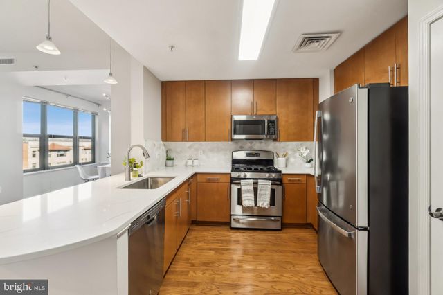 a kitchen with stainless steel appliances granite countertop a refrigerator stove microwave and sink