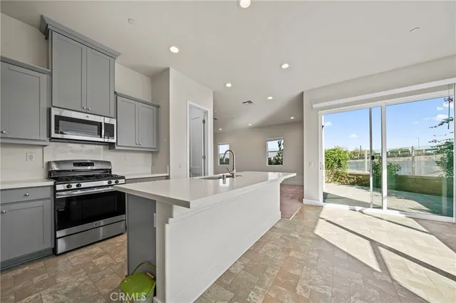 a large kitchen with stainless steel appliances lots of counter space and wooden floor
