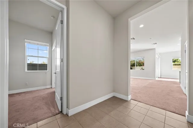 an empty room with windows and entrance to other room