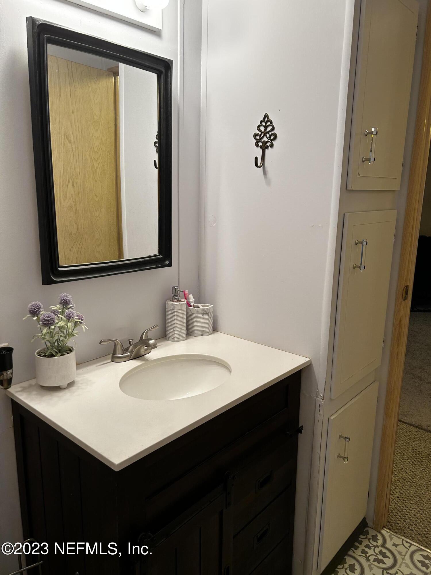130 Walker Drive Interlachen, FL 32148 - Photo 12 of 31 a bathroom with a sink vanity and a mirror