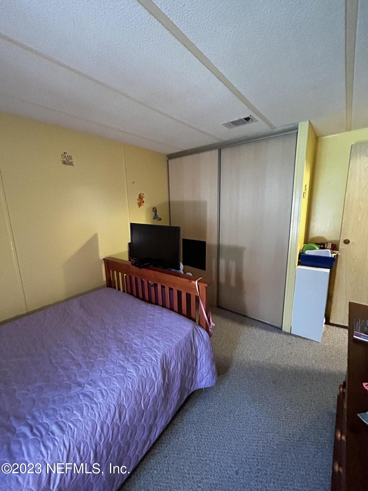 130 Walker Drive Interlachen, FL 32148 - Photo 14 of 31 a bedroom with a bed and a television