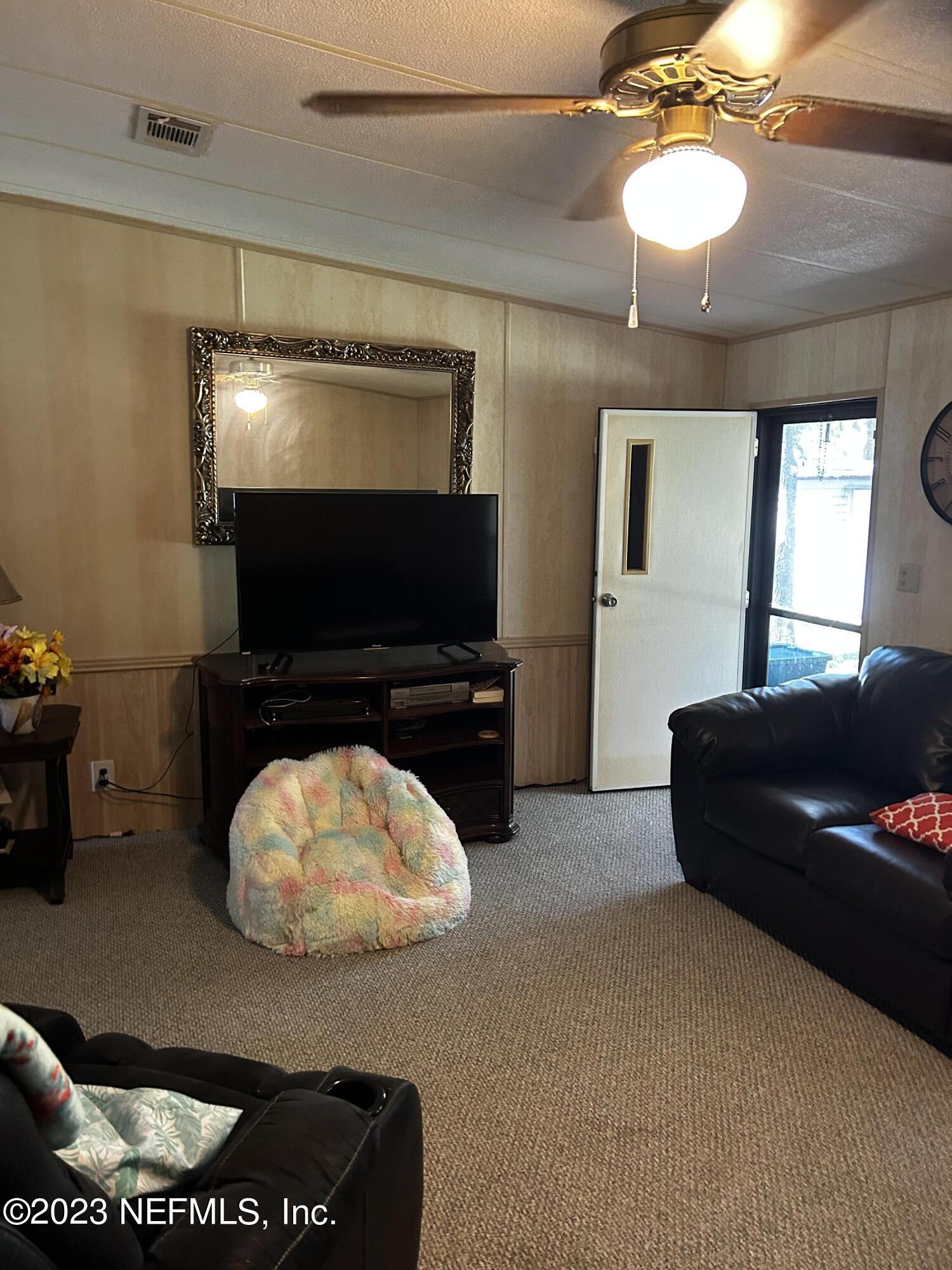 130 Walker Drive Interlachen, FL 32148 - Photo 16 of 31 a living room with furniture and a flat screen tv