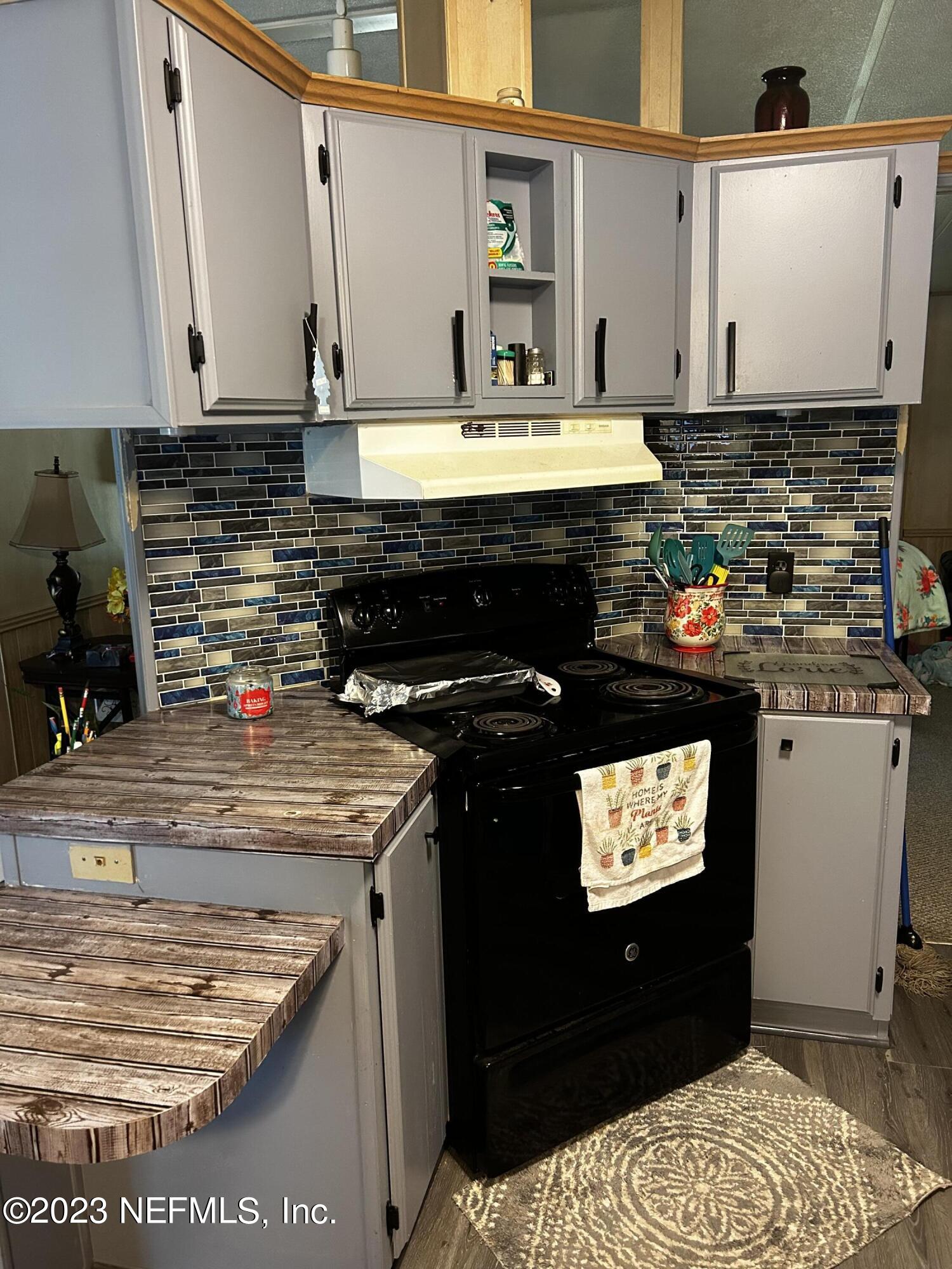 130 Walker Drive Interlachen, FL 32148 - Photo 17 of 31 a kitchen with stainless steel appliances granite countertop a stove a sink and a microwave