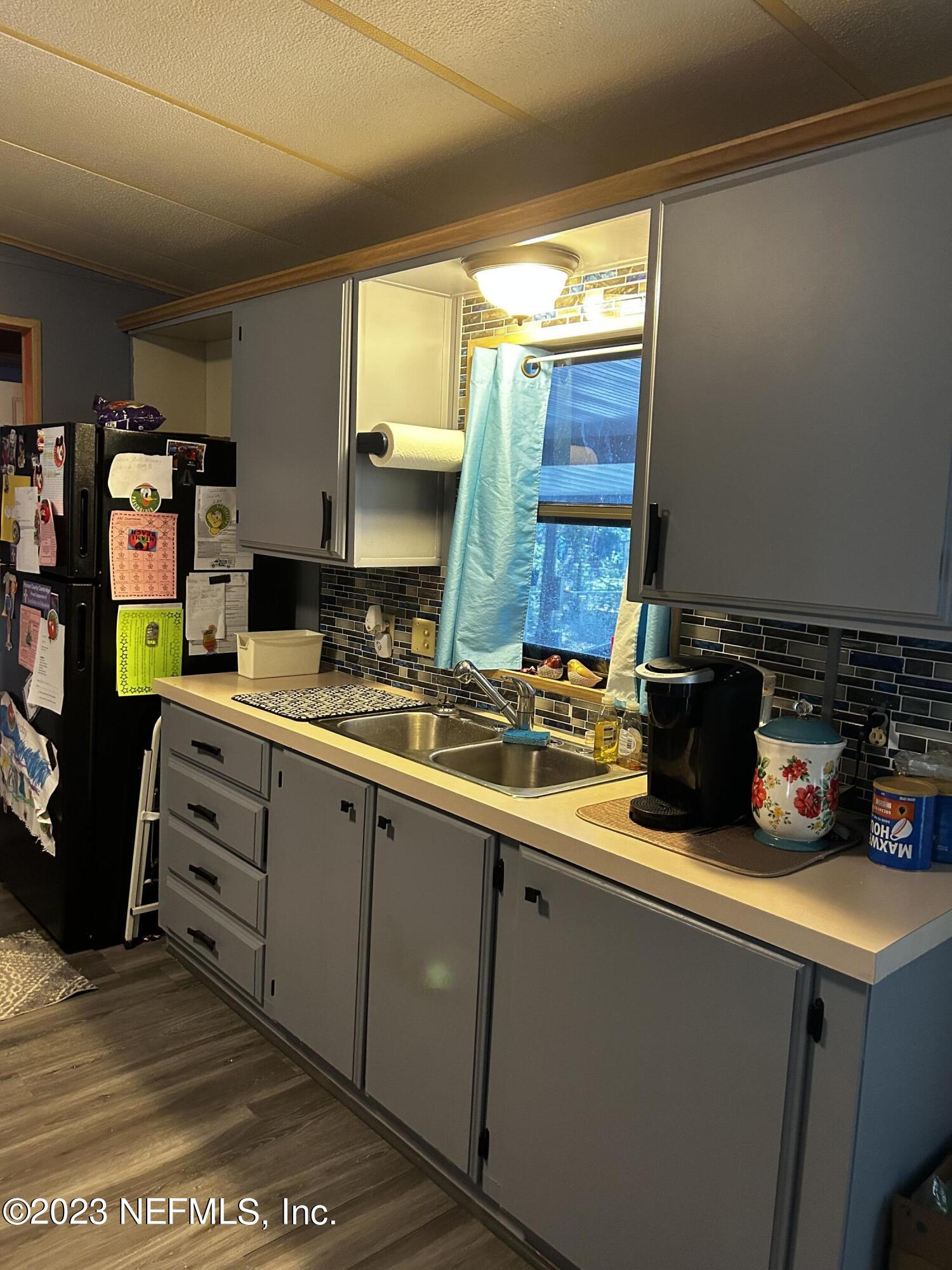 130 Walker Drive Interlachen, FL 32148 - Photo 19 of 31 a kitchen with sink a cabinets and appliances