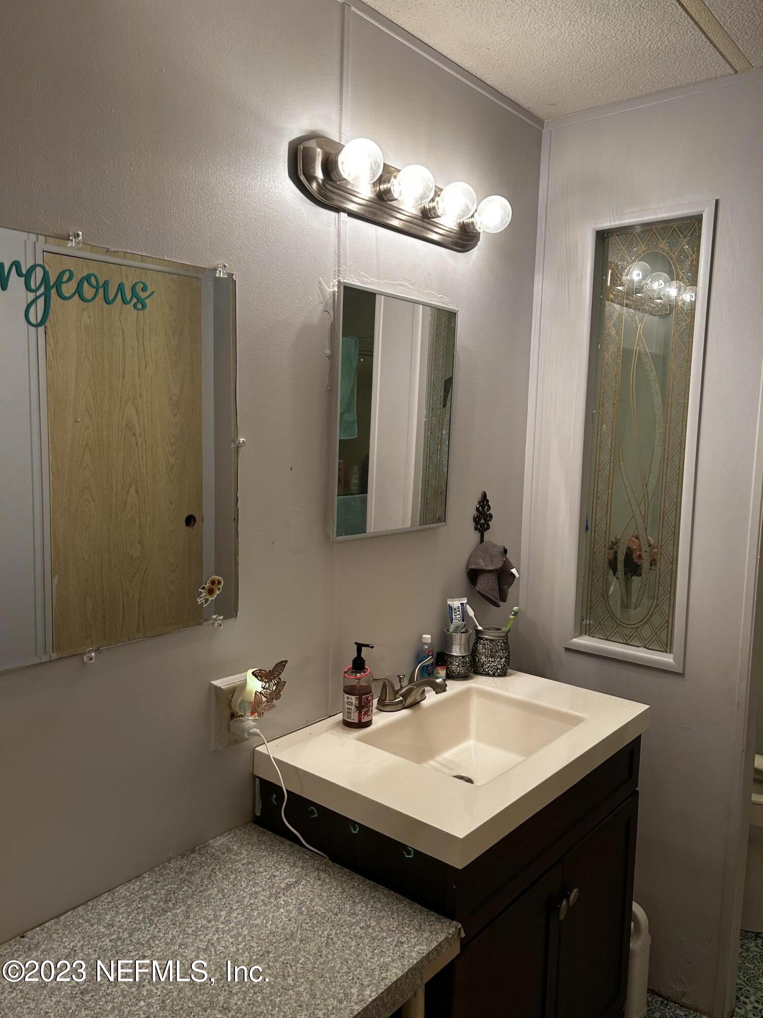 130 Walker Drive Interlachen, FL 32148 - Photo 24 of 31 a bathroom with a sink and a mirror