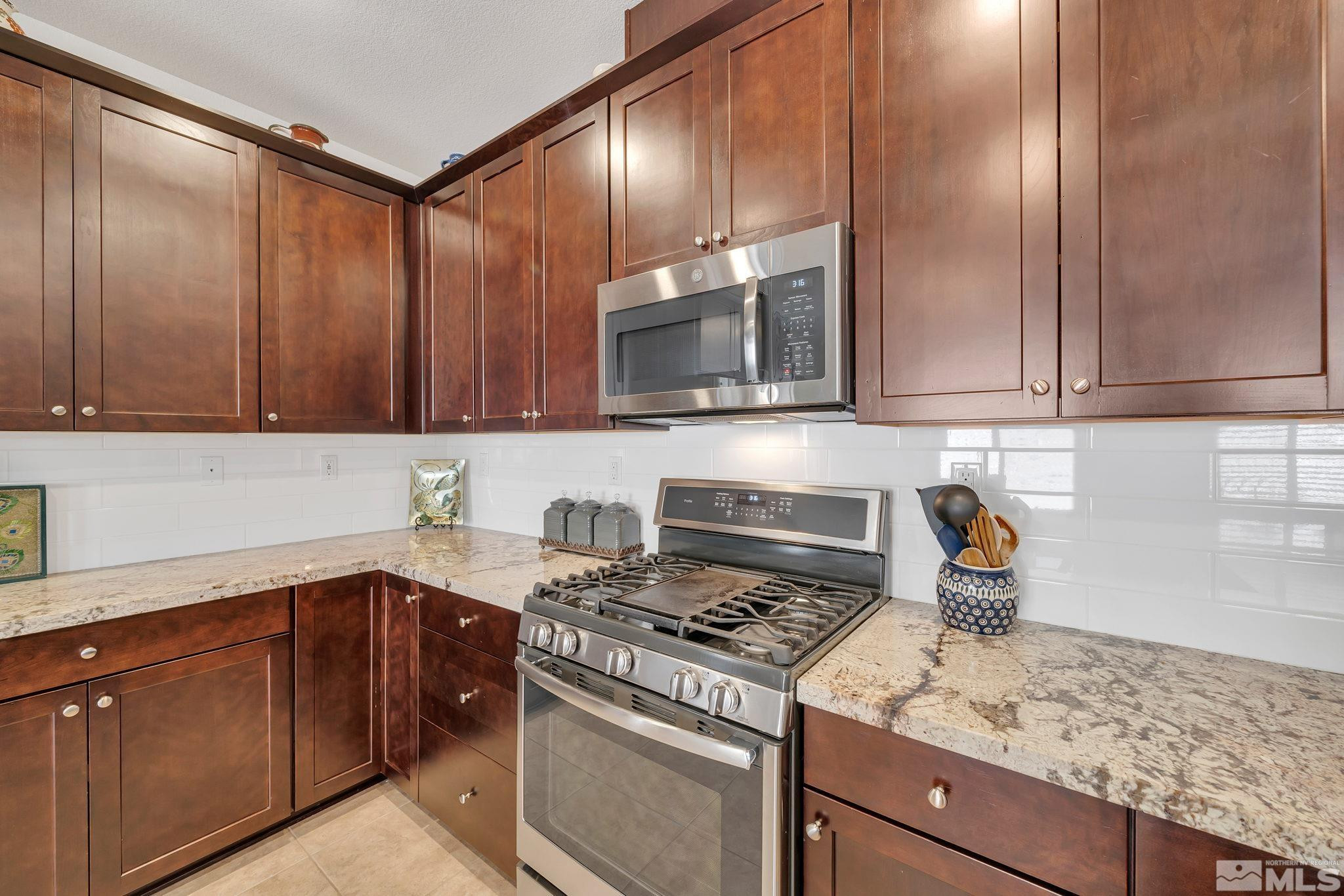 10490 Gold Mine Drive Reno, NV 89521 - Photo 15 of 40 a kitchen with granite countertop cabinets stainless steel appliances and a counter space