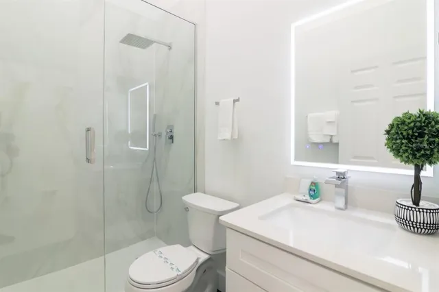 a bathroom with a sink a toilet and shower