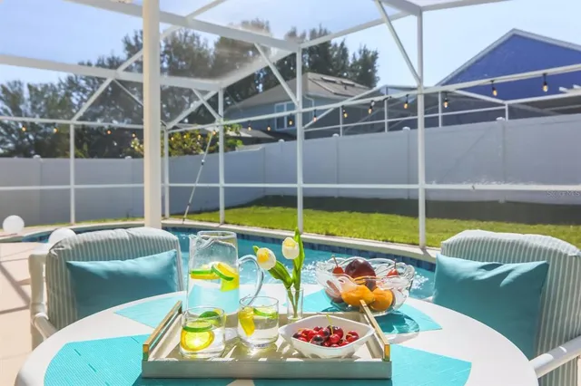 a view of a swimming pool with a dining table and chair