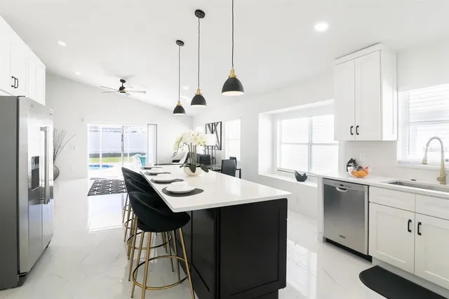 a kitchen with a sink a center island and cabinets