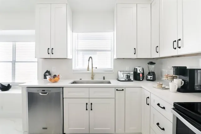 a kitchen with white cabinets and white appliances