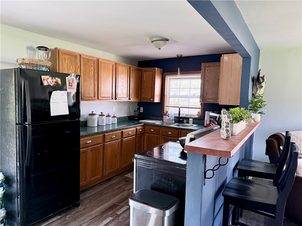 6800 Farmington Road Miamisburg, OH 45342 - Photo 8 of 32 This kitchen features rich wood cabinetry and a functional breakfast bar for casual dining.