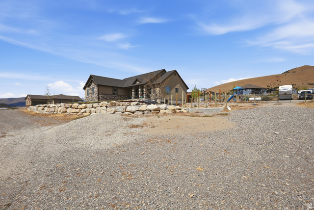 1588 West Rim Rock Drive Stockton, UT 84071 - Photo 48 of 61 Stone-accented exterior with a covered front porch featuring stone columns