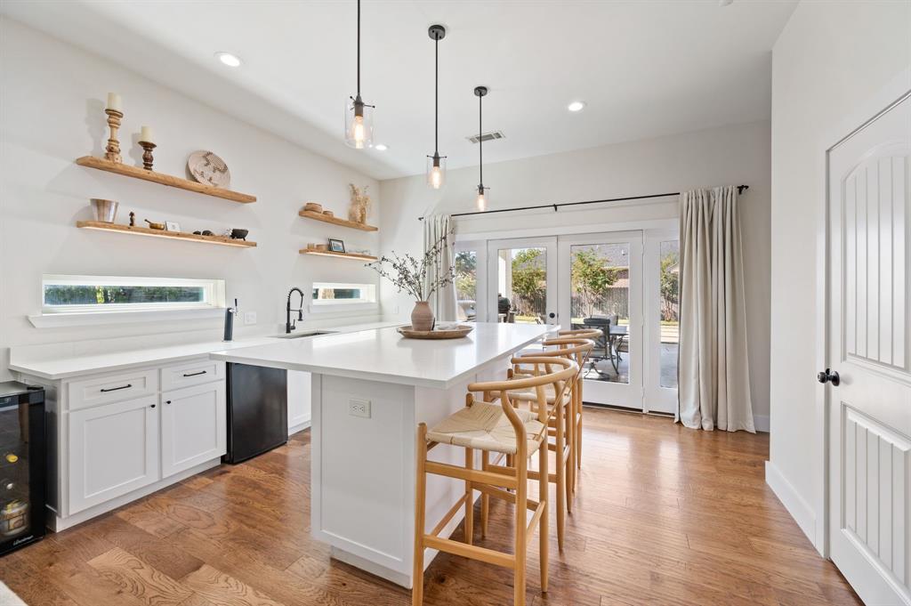 504 Main Street Roanoke, TX 76262 - Photo 13 of 40 a kitchen with stainless steel appliances granite countertop a refrigerator a sink dishwasher a dining table and chairs with wooden floor