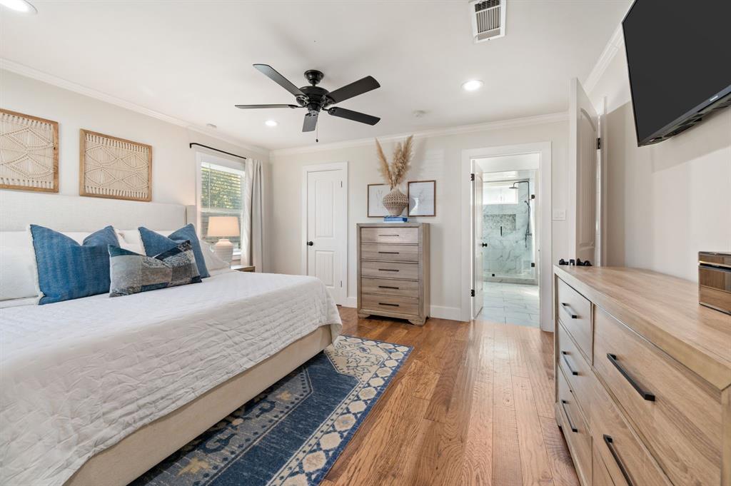 504 Main Street Roanoke, TX 76262 - Photo 16 of 40 a spacious bedroom with a bed and a flat screen tv