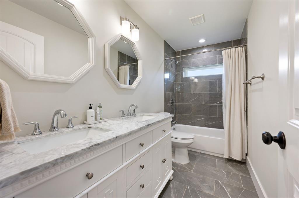 504 Main Street Roanoke, TX 76262 - Photo 27 of 40 a bathroom with a granite countertop sink a toilet a mirror and shower