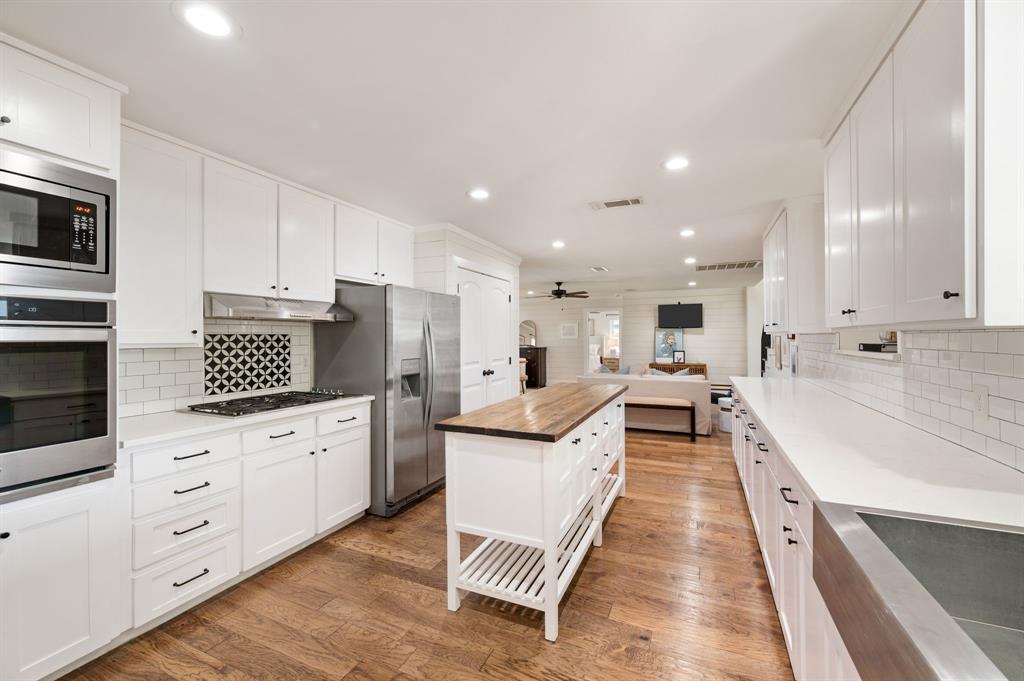 504 Main Street Roanoke, TX 76262 - Photo 10 of 40 a large kitchen with stainless steel appliances kitchen island granite countertop a large counter top a sink and a stove