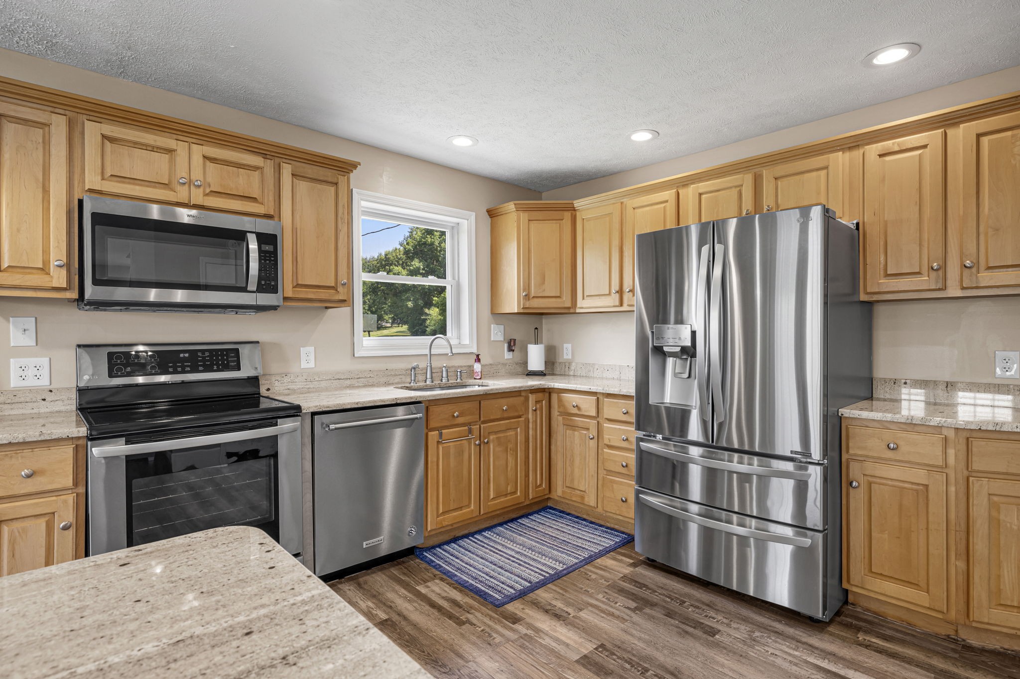 670 Still Pond Road Columbia, TN 38401 - Photo 17 of 43 a kitchen with granite countertop wooden cabinets a refrigerator and a stove top oven