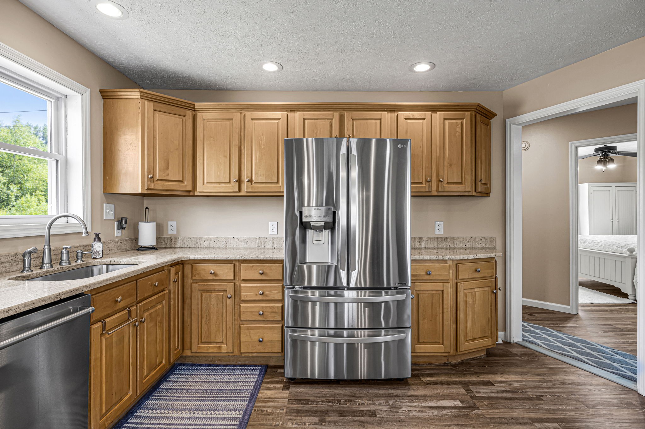 670 Still Pond Road Columbia, TN 38401 - Photo 18 of 43 a kitchen with kitchen island granite countertop a refrigerator oven a sink and dishwasher with wooden floor