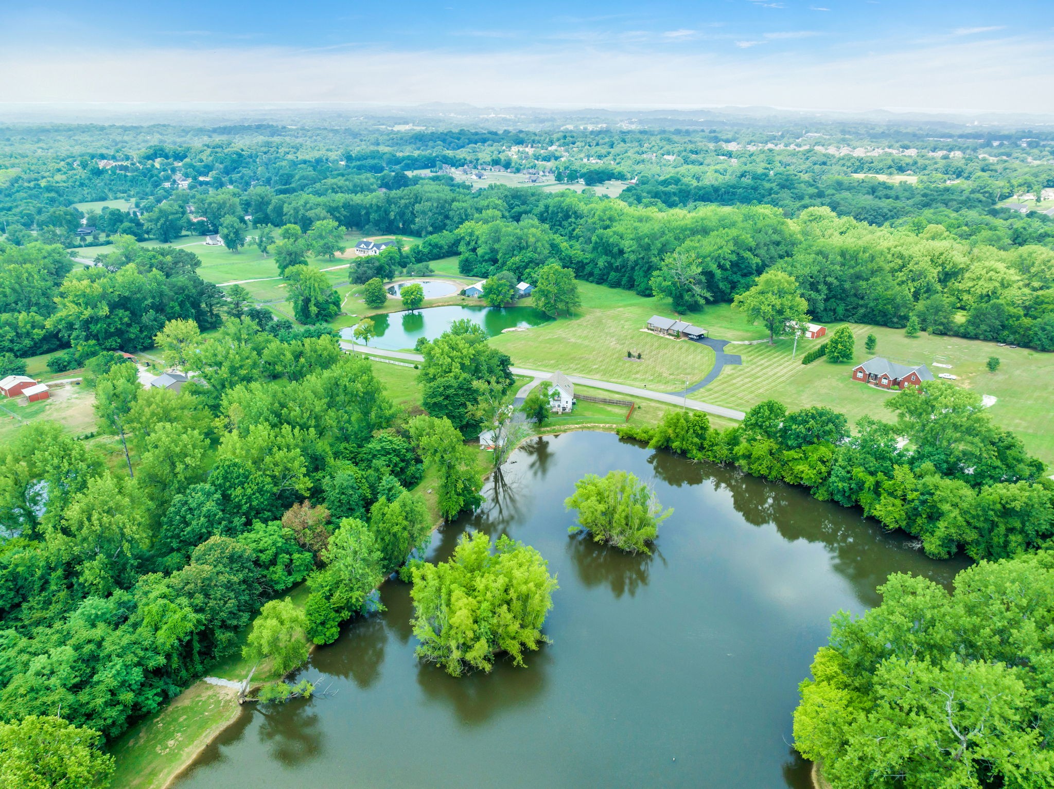 670 Still Pond Road Columbia, TN 38401 - Photo 42 of 43 an aerial view of green landscape with trees houses and lake view