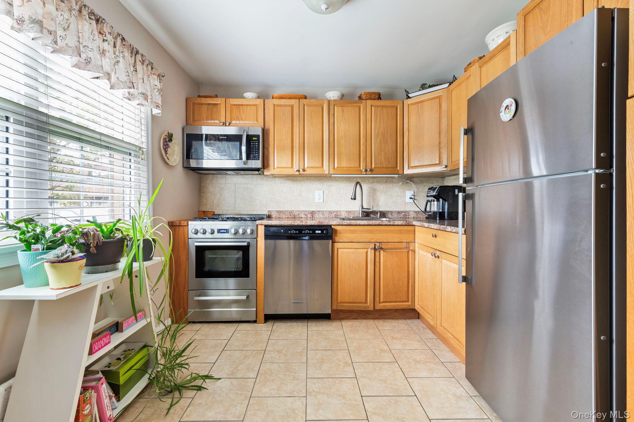 248 Mariners Way Copiague, NY 11726 - Photo 5 of 18 a kitchen with stainless steel appliances granite countertop a refrigerator sink and stove