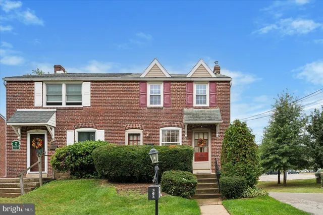 a front view of a house with yard and green space