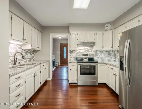 a kitchen with stainless steel appliances white cabinets and a sink