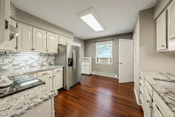 a kitchen with granite countertop a refrigerator stove top oven and sink