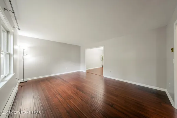 a view of an empty room and wooden floor