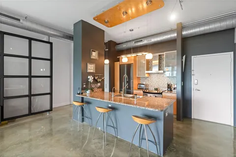 a kitchen with stainless steel appliances granite countertop a sink a counter space and a window