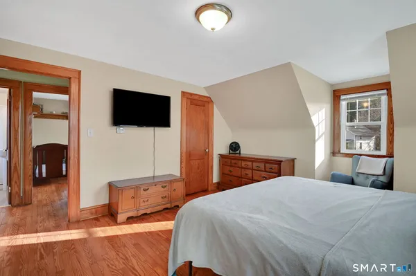a bedroom with a bed and wooden floor