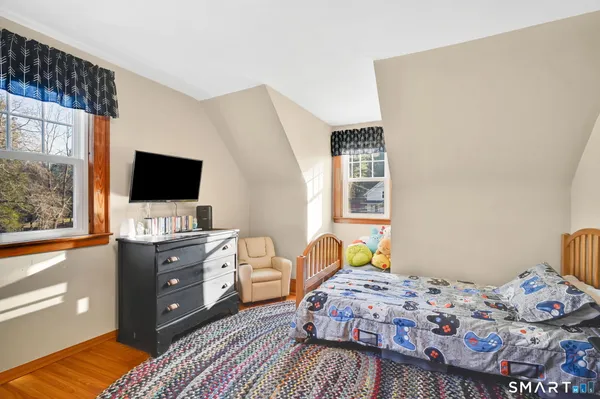 a view of a bedroom with furniture and wooden floor