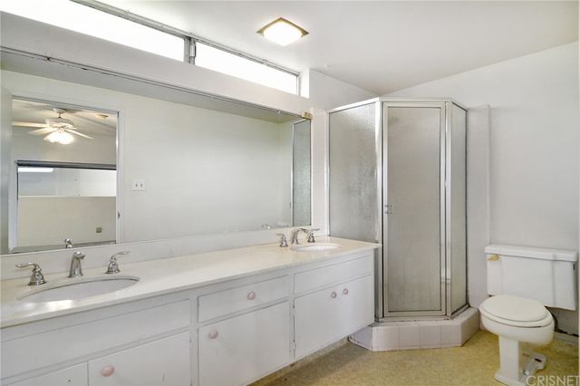 a bathroom with a double vanity sink toilet and a mirror