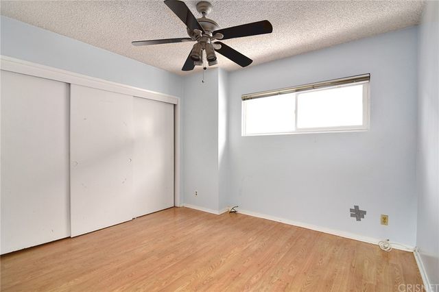 an empty room with a window and a fan