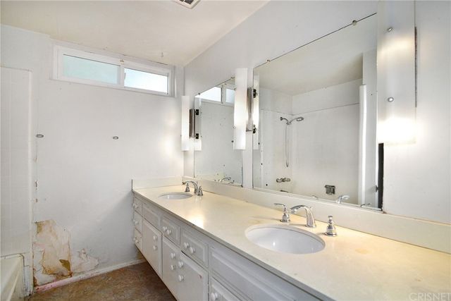 a bathroom with a double vanity sink and a mirror